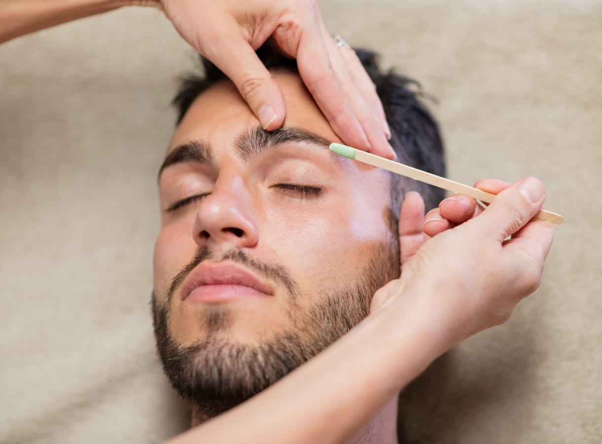Male client having eyebrows waxed